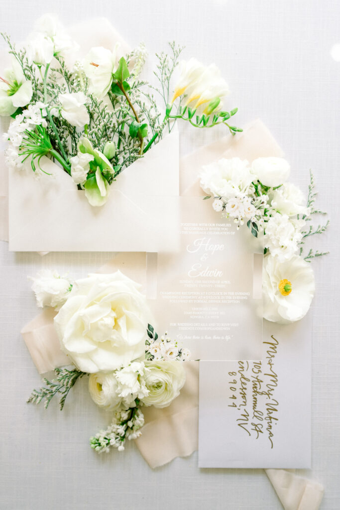 white and gold acrylic wedding invitation suite with white flowers