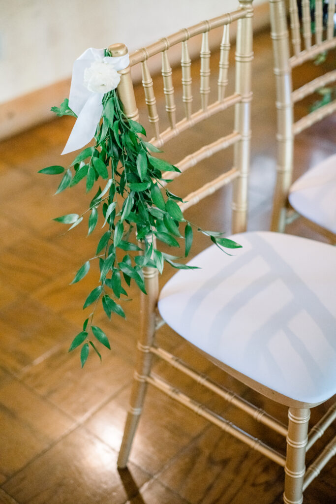 gold wedding reception chairs with greenery