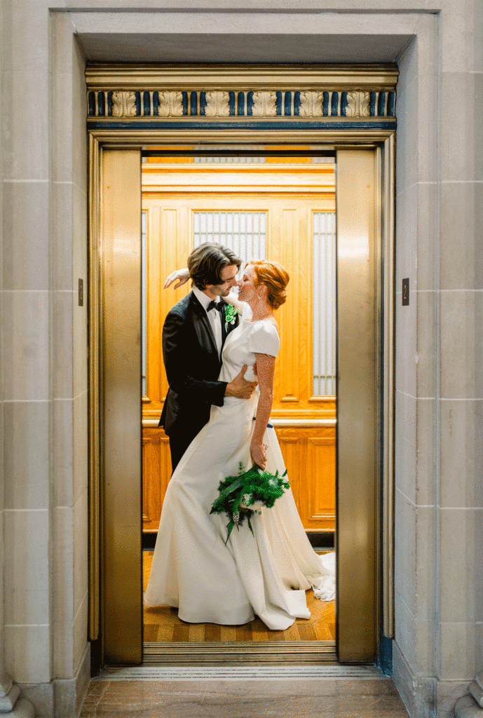 Newlyweds sharing an intimate moment in an ornate elevator at San Francisco City Hall during their wedding.