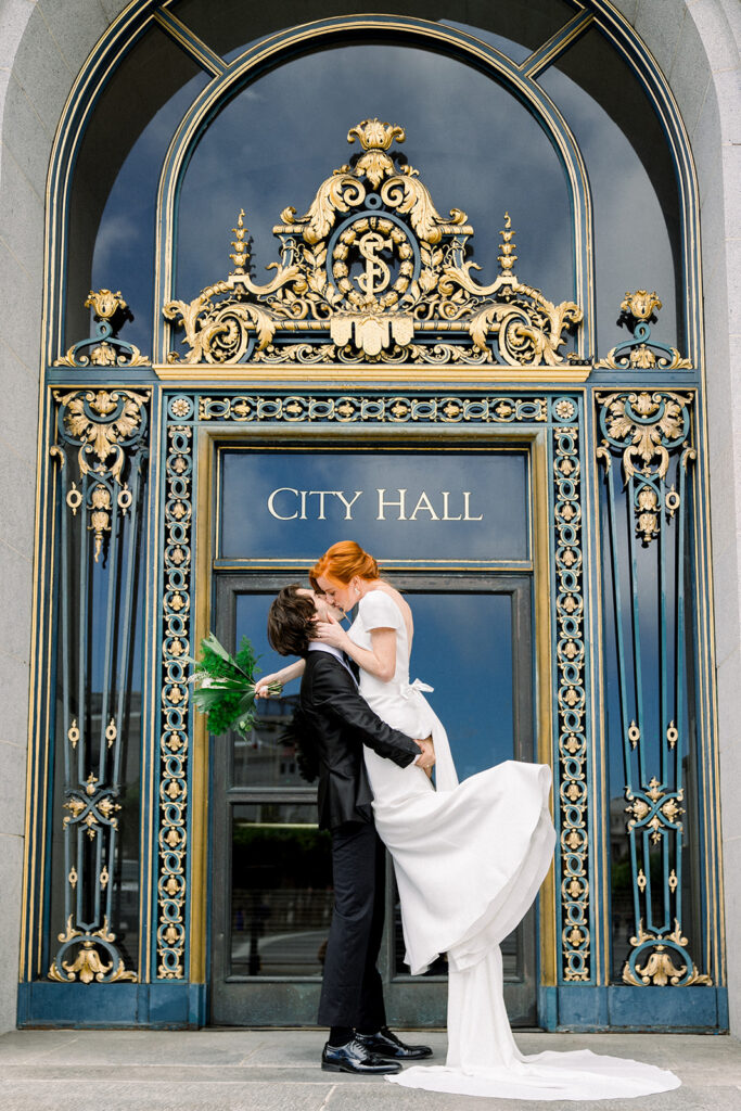 Elegant San Francisco wedding couple posing in front of the iconic City Hall entrance, showcasing the venue’s grandeur.