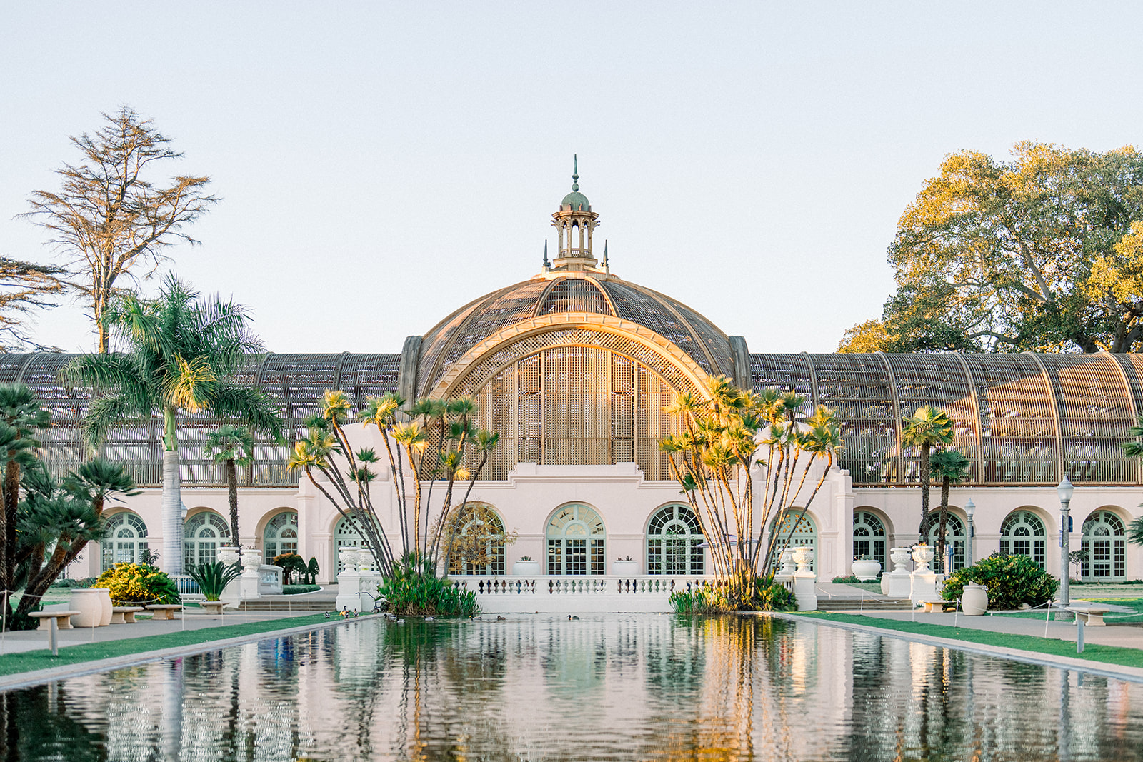 Historic Botanical Building in Balboa Park reflecting over the pond at golden hour during an engagement session in San Diego, California