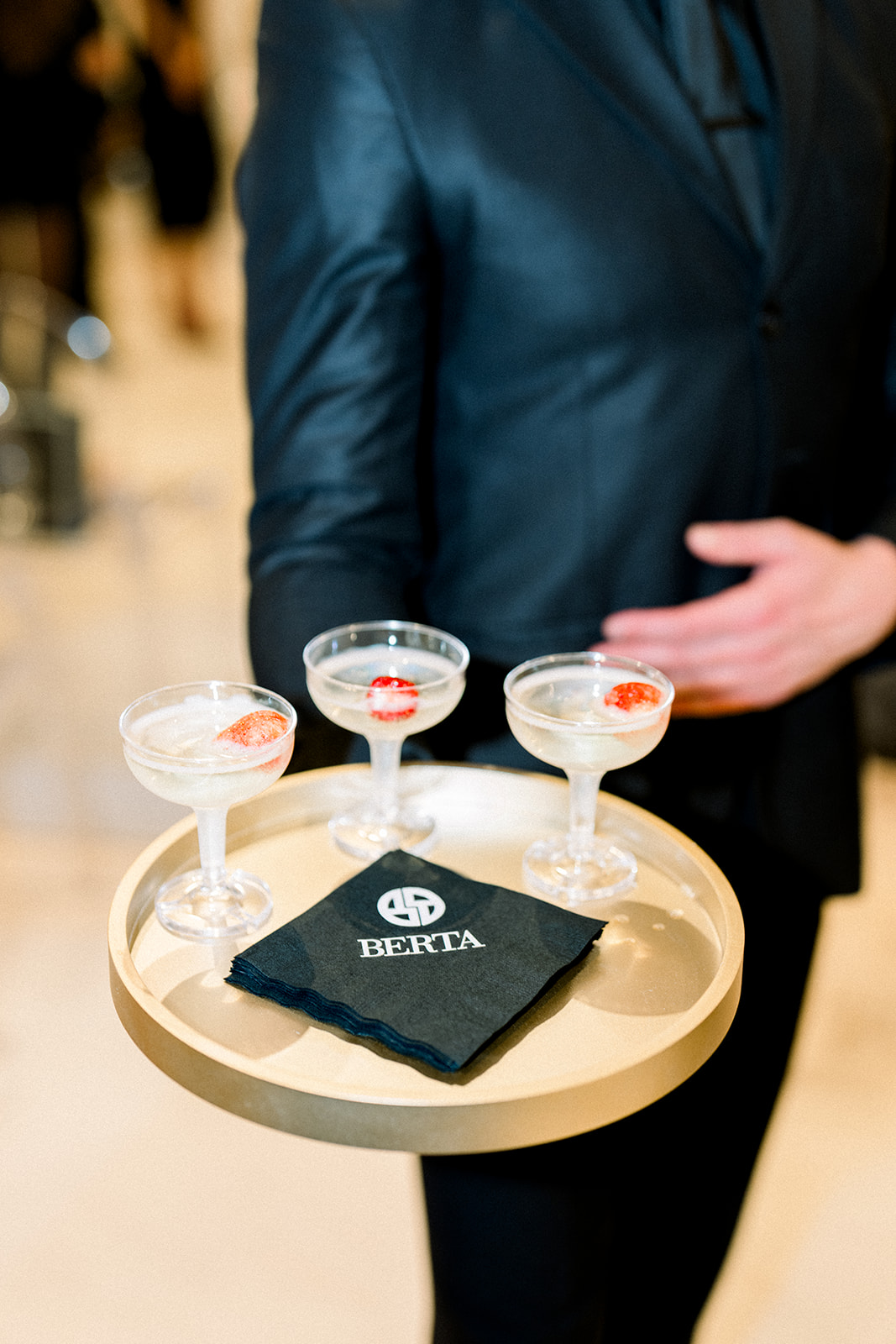 Champagne tray with crystal coupes garnished with strawberries served on branded BERTA napkins during the BERTA Los Angeles bridal event