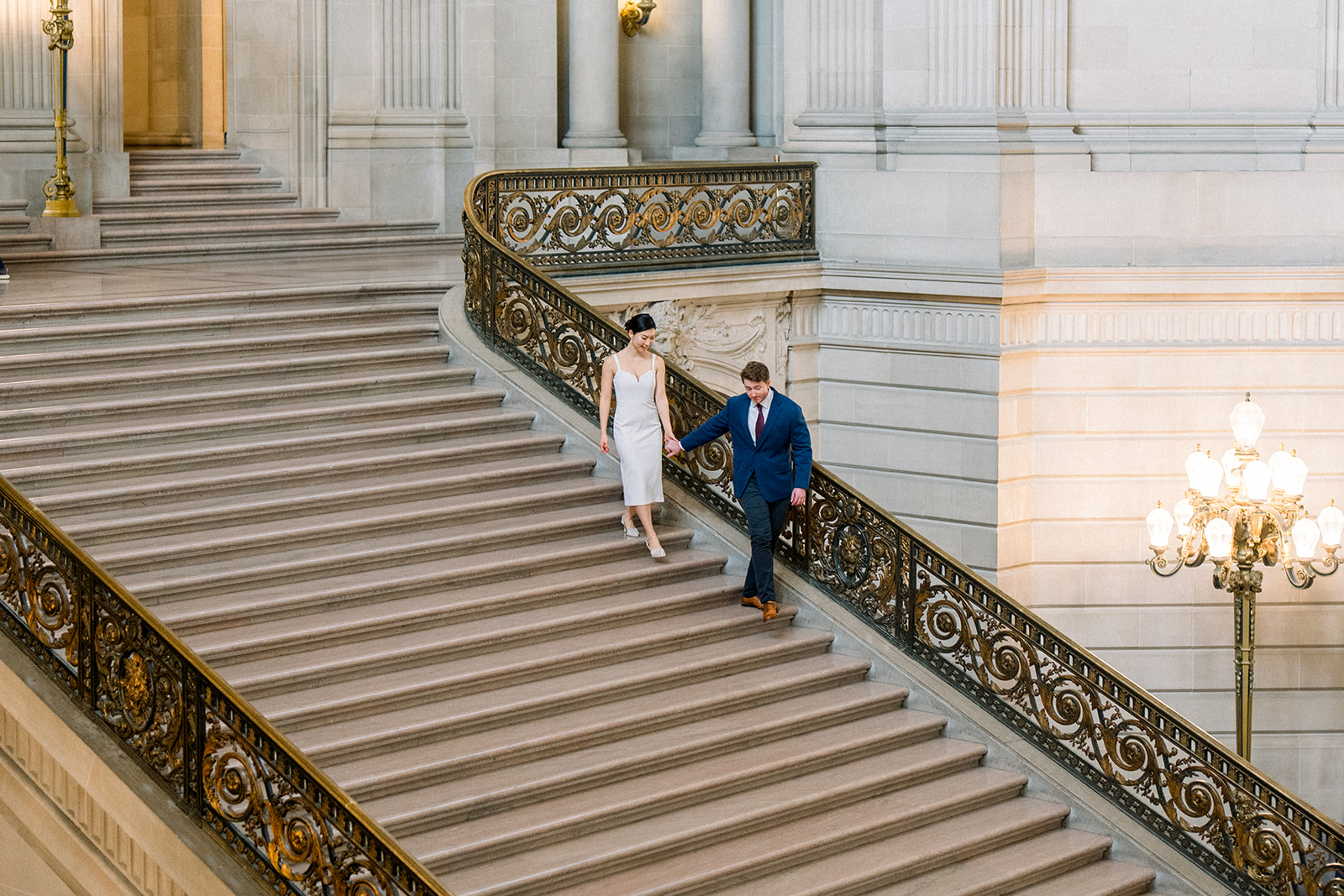 Bay Area couple walks together inside San Francisco City Hall during elopement