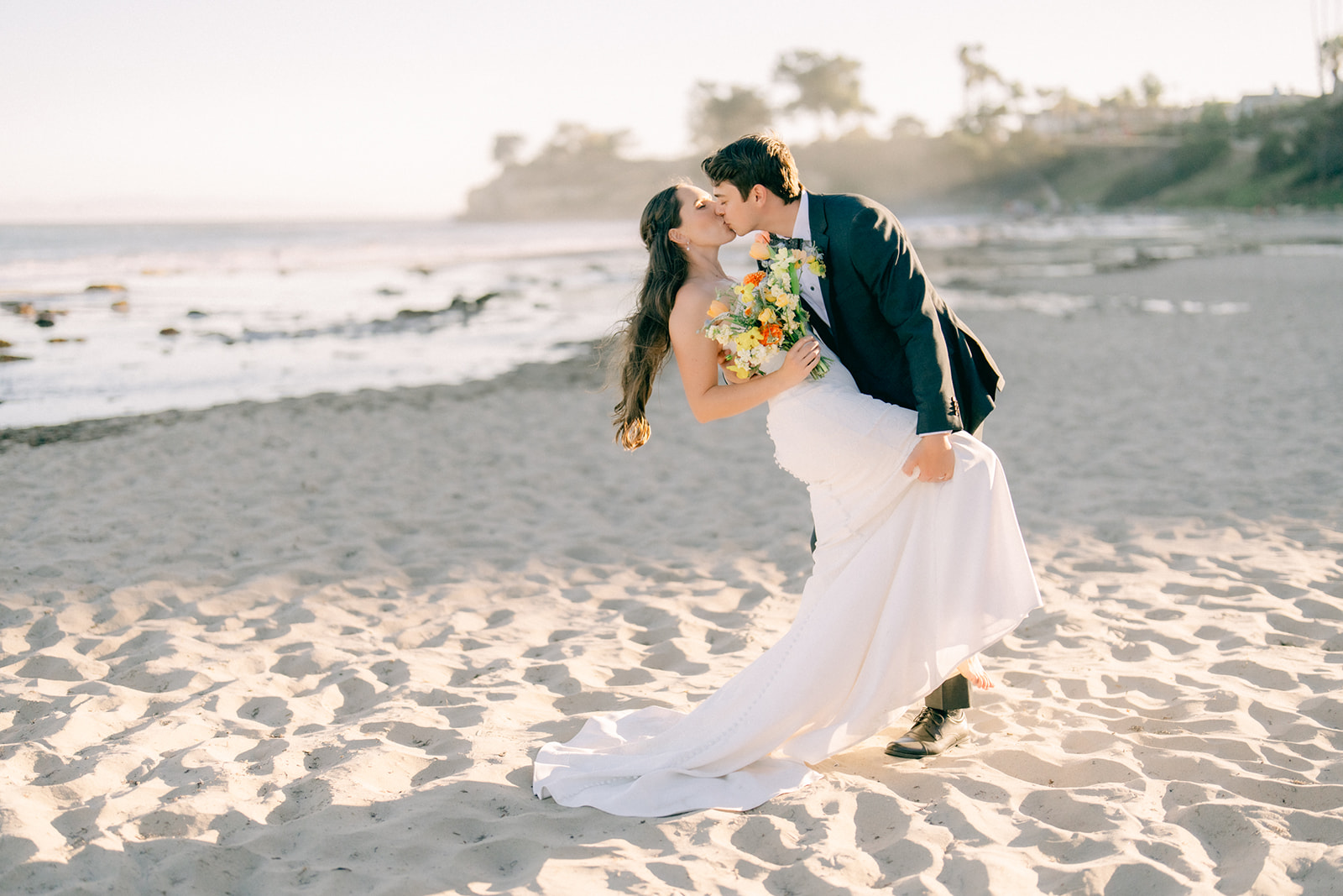 Bride and groom sharing a dipped kiss on the sand at Leadbetter Beach during an intimate Santa Barbara wedding